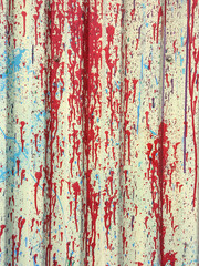 Abstract messy paint stains and splashes on corrugated metallic wall.