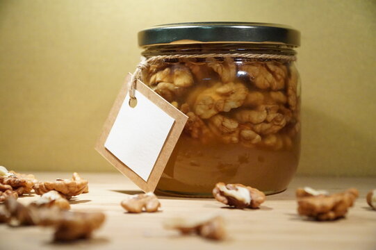 Jar with nuts in honey and white label, close-up