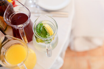 Summer fresh drinks in pitchers among other juices served on the table.