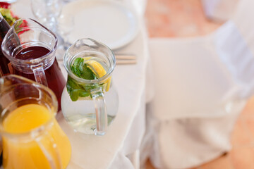 Summer fresh drinks in pitchers among other juices served on the table.