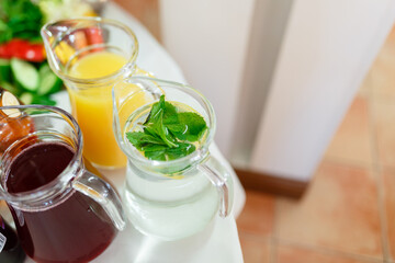 summer mint drink pitcher among others juices served on the table.