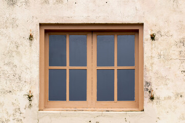 Fototapeta na wymiar Wood framed windows on plaster wall