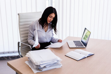 Businesswoman sitting in office and working with some documents
