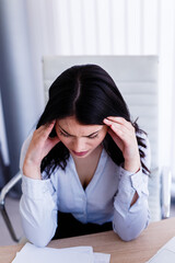 Businesswoman having headache in her office after doing very hard work