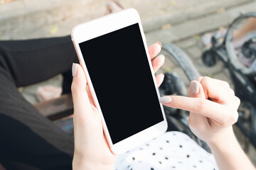 woman holding smartphone in the benches in the park. can be used for ad.