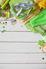 Materials for sewing. Colored fabric, thread and buttons on a white background. Needle bed with colored pins.