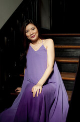 Obraz na płótnie Canvas A pregnant woman wearing a purple dress indoors