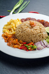 Rice Seasoned with Shrimp Paste, Thai food on white dish over dark granite table.