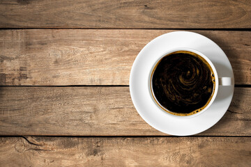 Top view of white coffee cup on a wood background with copy space.