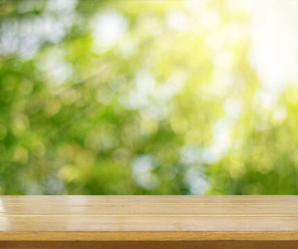 wooden tabletop surface with fresh green nature background