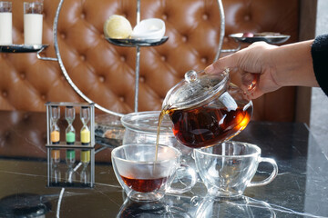 Closeup Glass cup of organic tea and glass teapot on marble table, hot and delicious, Healthy drink concept.