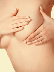 Woman examining her breasts for breast cancer