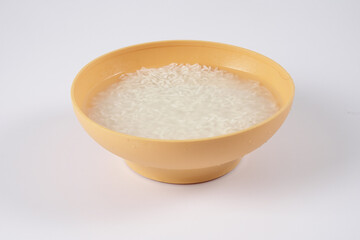 Fototapeta na wymiar Soak rice in yellow bowl over white background