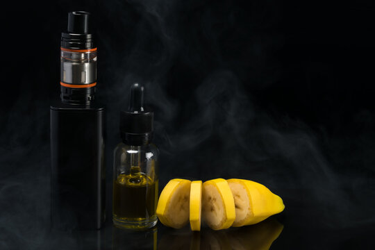 Aroma of a yellow banana in a bottle next to an electronic cigarette on a black background