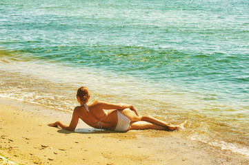 Fototapeta na wymiar Young woman on the beach .The concept of summer vacation
