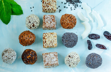 Healthy raw energy balls with cocoa, coconut, sesame, chia on a blue background. Love for a healthy vegan food concept