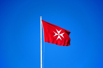 Maltese flag against a blue sky, Valletta, Malta.
