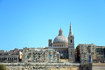 Fototapeta na wymiar View of St Pauls Anglican Cathedral and the Basilica of Our Lady of Mount Carmel seen from the Grand Harbour. Valletta, Malta.