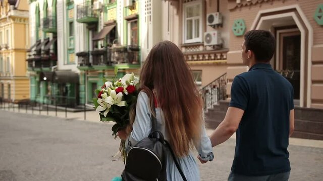Affectionate couple walking down old city street