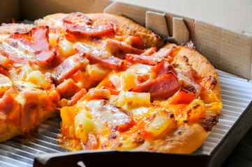 Close up of pizzas with variety of toppings and cheese in cardboard take out boxes with open lid