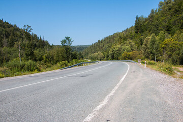 Fototapeta na wymiar Road in mountain and trees around in a summer day