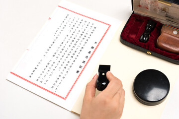 不動産売買証書をよく読み押印する女性