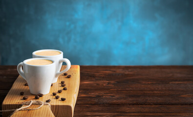 White cups of espresso on a wooden tray,coffee beans,blue background