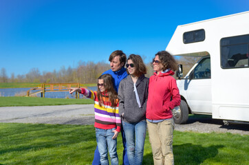 Family vacation, RV travel with kids, happy parents with children have fun on holiday trip in motorhome, camper exterior
