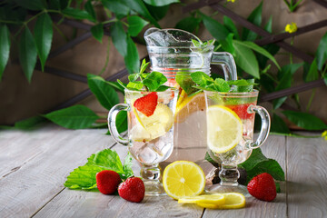 Fresh summer healthy drink with lemon and strawberries with ice.