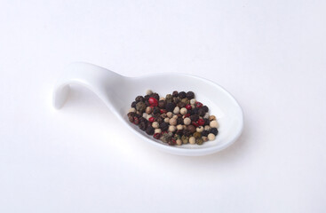 Fototapeta na wymiar mixed black, white and red pepper corns in bowl isolated on white background.