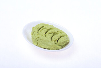 Bowl with wasabi isolated on white background.
