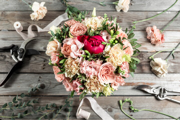 The florist desktop with working tools on gray old wooden background