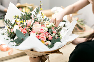 Workshop florist, making bouquets and flower arrangements. Woman collecting a bouquet of flowers....