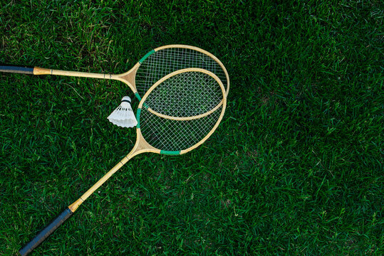 Badminton rackets and shuttlecocks isolated on green, top view, Fresh lawn
