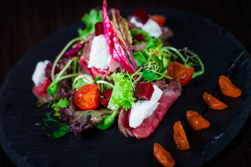 Green salad with beef and tomatoes. Food style in the restaurant