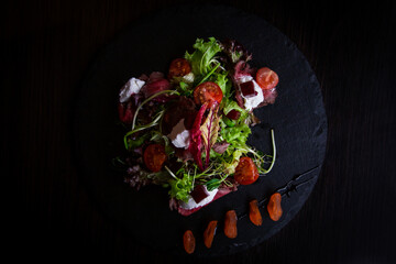 Green salad with beef and tomatoes. Food style in the restaurant