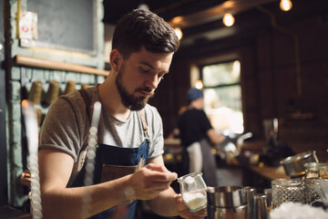 Young male bartender preparing an alcohol cocktail