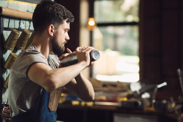 Young male bartender preparing an alcohol cocktail