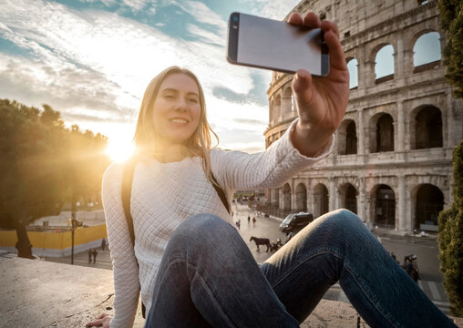 Woman tourist selfie with phone camera in hands near the Coliseu