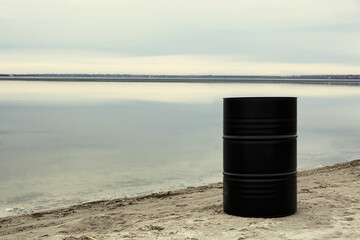 Big black barrel on beach. Environment pollution concept