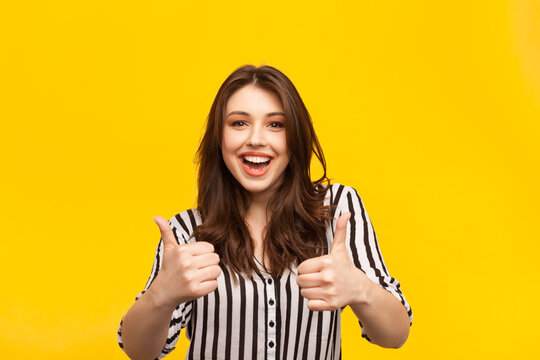 Delighted woman posing with thumbs up