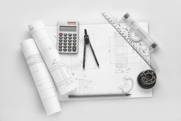 Engineering supplies and part blueprints on white background