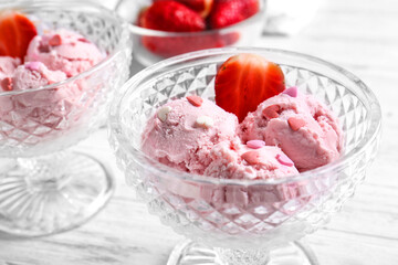 Delicious ice-cream with strawberry in glass bowls on table
