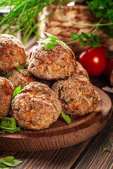 Stack of baked meatballs on a chopping board