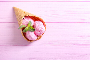 Strawberry ice-cream cone on wooden background