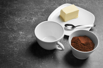 Ground coffee and butter on gray background