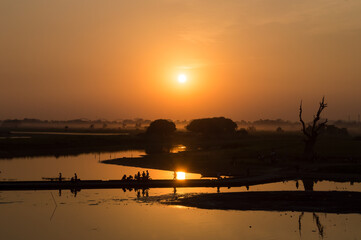 Silhouettes of people on Taungthaman Lake at sunset, in Amarapura, Mandalay, Myanmar