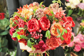 Woman holding beautiful blooming bouquet of flowers in shop