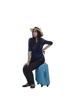 Tired young asian traveler woman sitting on suitcase