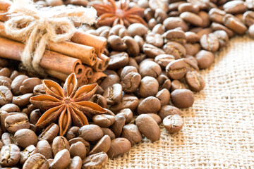 Coffee beans with anise and cinnamon on burlap.